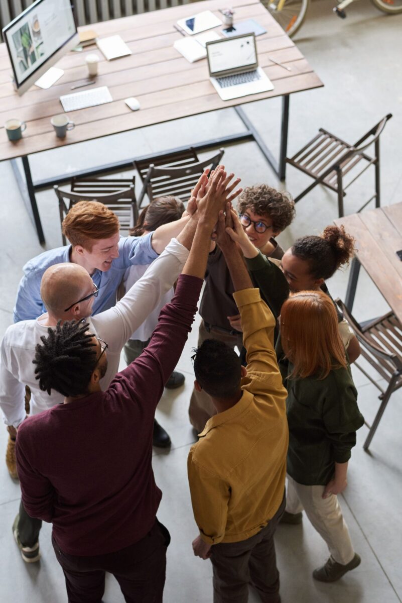 A team of professionals joining hands in an office, working together