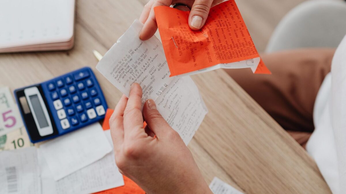 A desk with a calculator, receipts and notes used to work out guest post costs