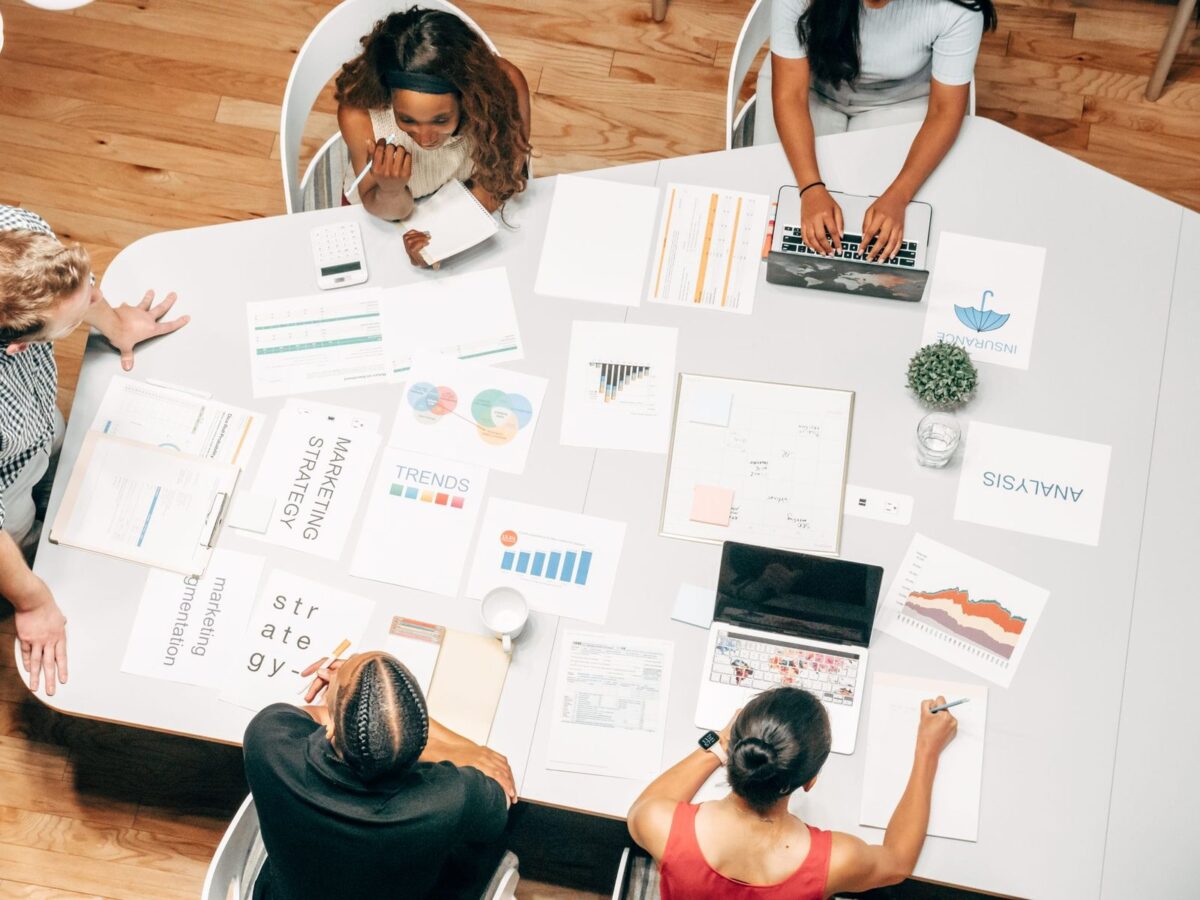 A team in a strategy meeting around a table, planning a link building campaign