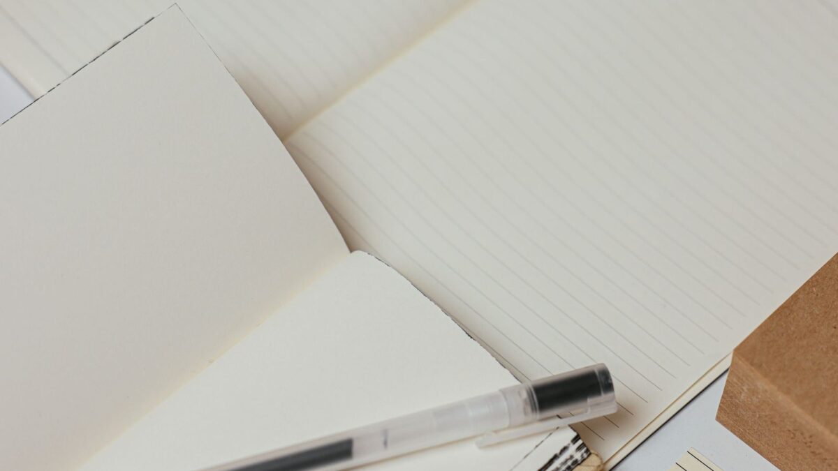 Notebooks and pens laid side by side on a desk, compared together